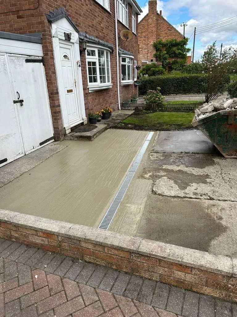 Installation of a linear drain channel in a concrete driveway.